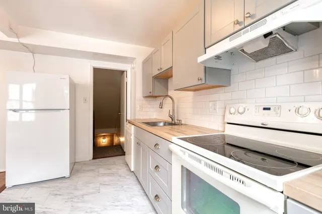 a view of a kitchen with a sink and refrigerator