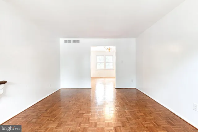a view of a big room with wooden floor and windows