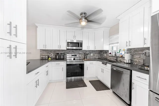 a kitchen with granite countertop white cabinets white stainless steel appliances with a sink and dishwasher