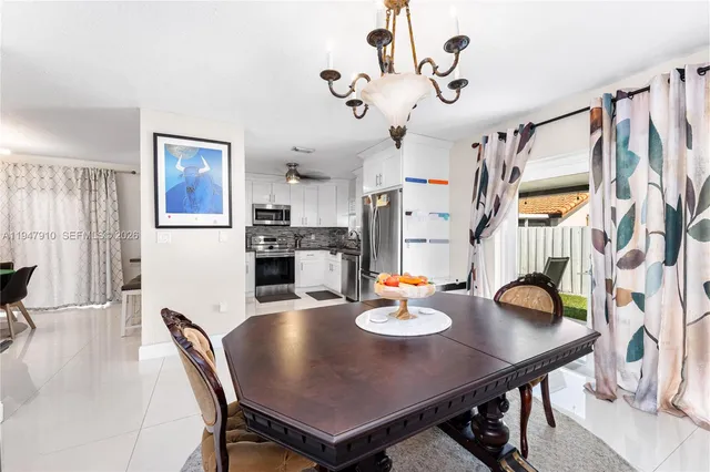 a view of a dining room and livingroom with furniture wooden floor a chandelier