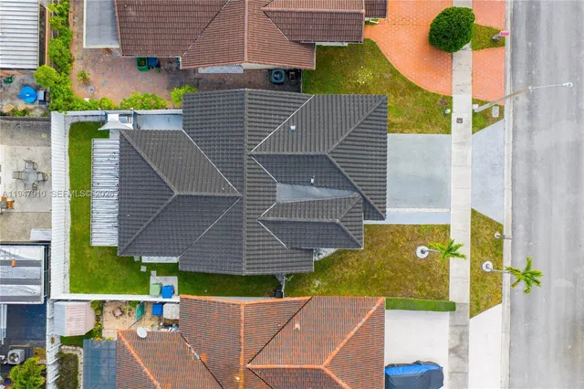 an aerial view of house with yard and swimming pool