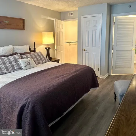 a spacious bedroom with a bed and wooden floor