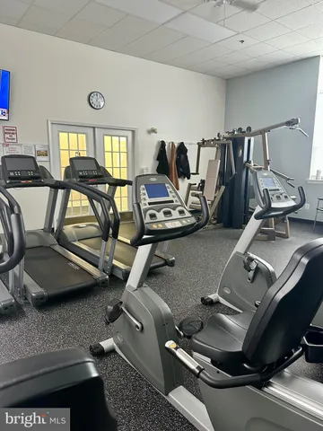 a living room with furniture a piano and wooden floor