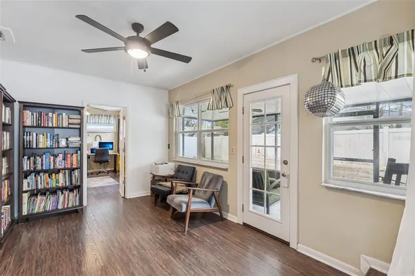 a living room with furniture wooden floor and a book shelf