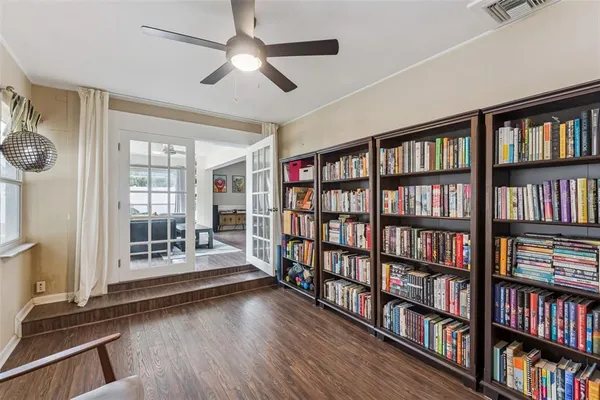 a view of an empty room with windows book shelves