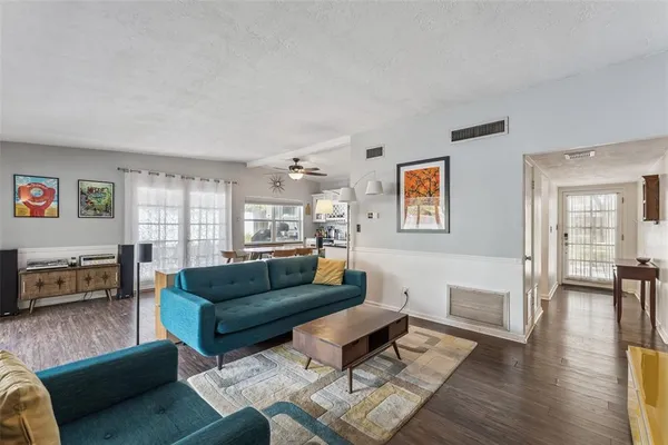 a living room with furniture and a wooden floor