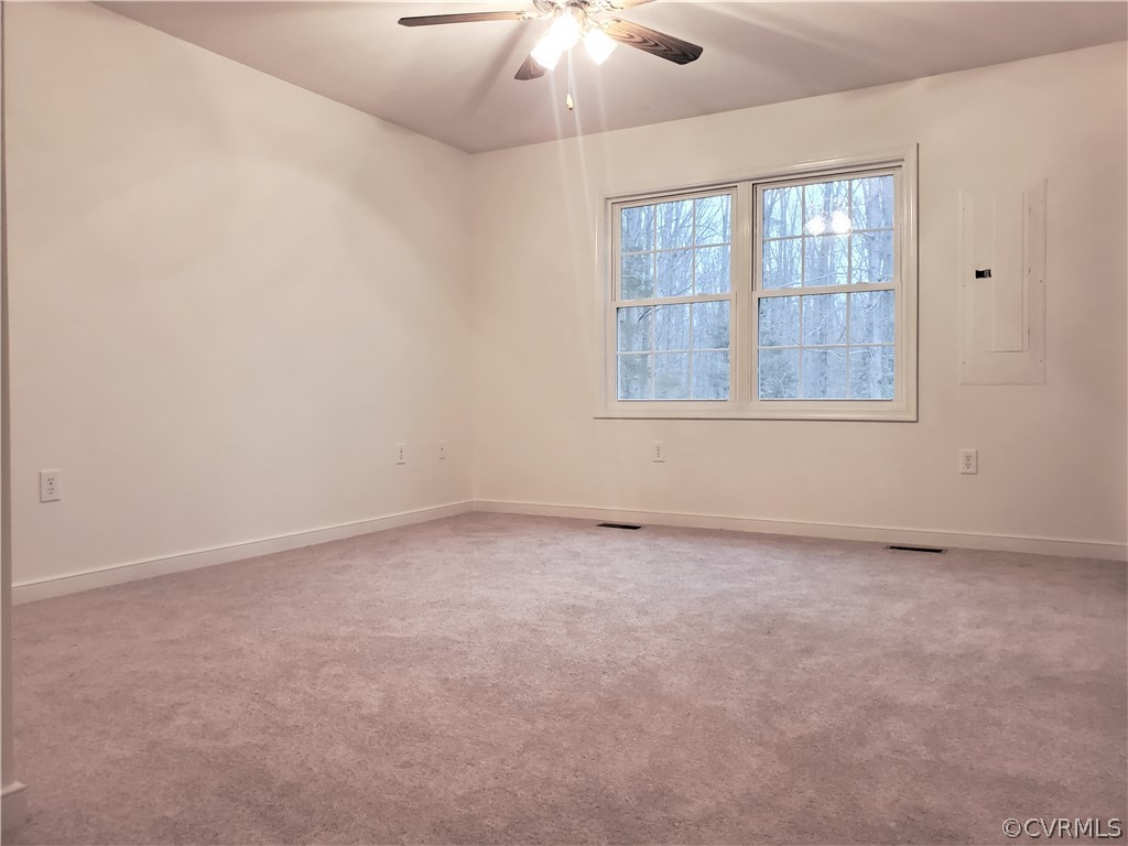 443 Lazy Acres Road Bumpass, VA 23024 - Photo 7 of 19 an empty room with a chandelier fan and windows