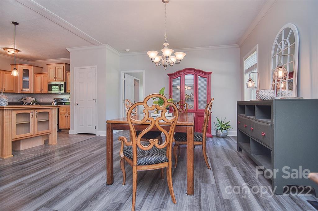 130 Printhad Road Dallas, NC 28034 - Photo 16 of 43 a view of a dining room with furniture a chandelier and wooden floor