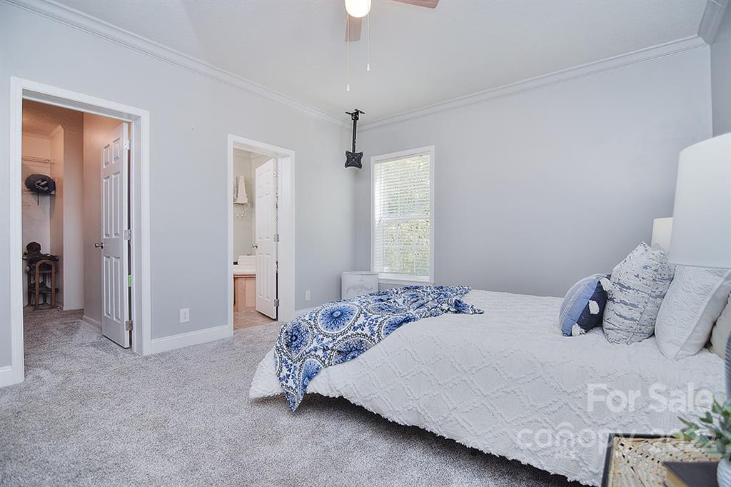 130 Printhad Road Dallas, NC 28034 - Photo 22 of 43 a bedroom with a bed and a chandelier