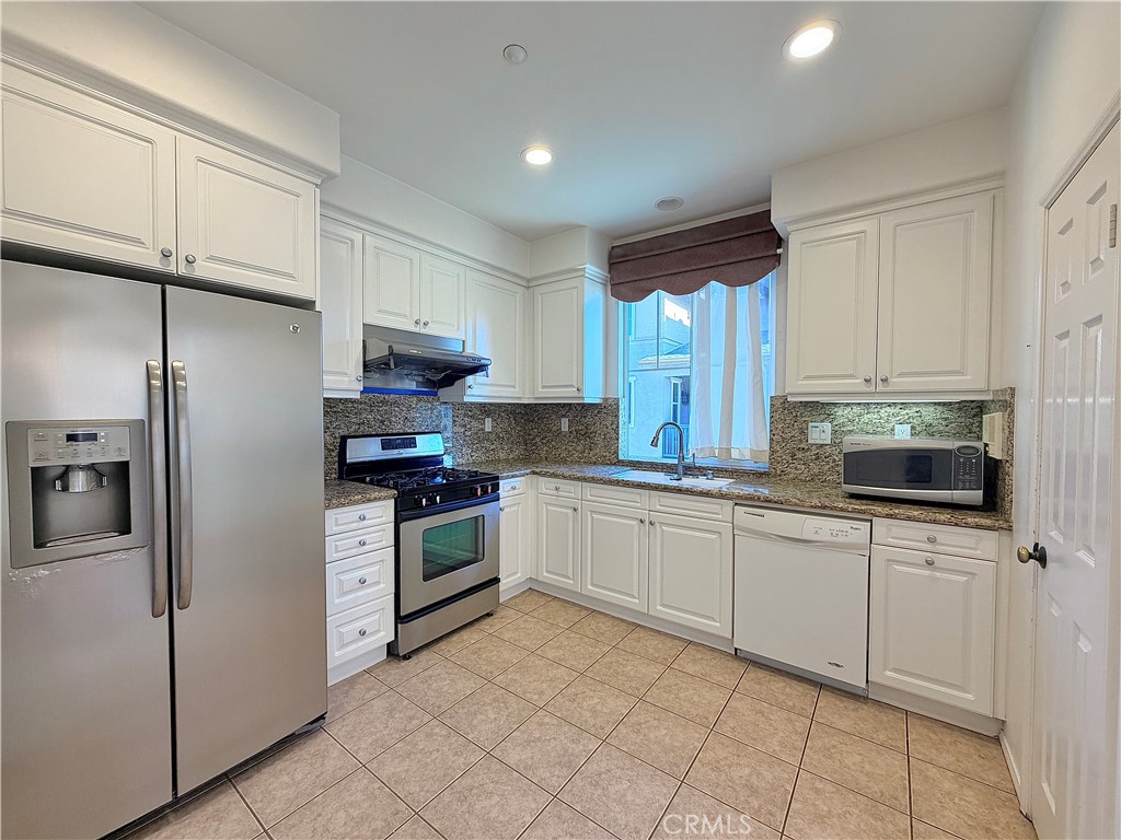 111 Liberty Street Tustin, CA 92782 - Photo 2 of 8 a kitchen with white cabinets and appliances