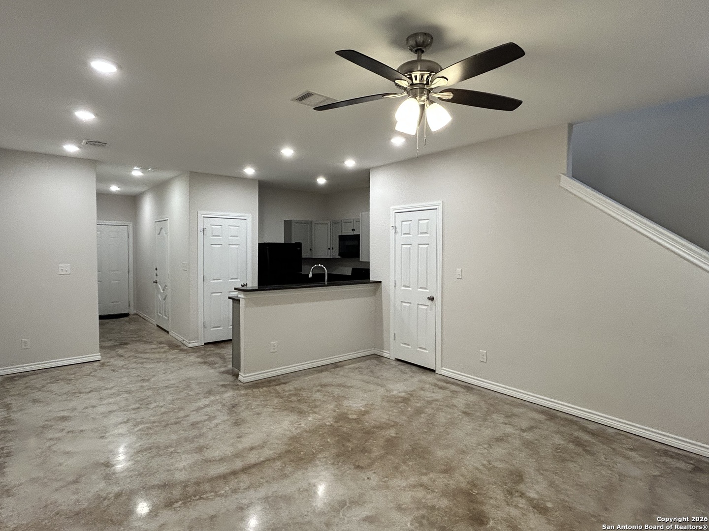 6926 Crestway Road, Unit 3 San Antonio, TX 78239 - Photo 5 of 13 a view of an empty room with kitchen view and a ceiling fan