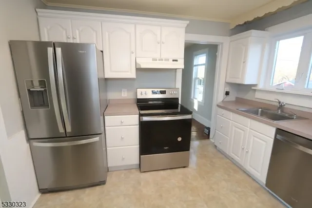 a kitchen with a refrigerator sink and cabinets