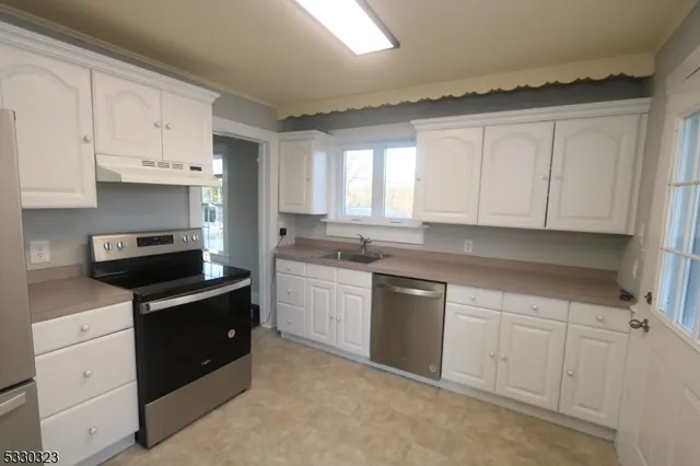 a kitchen with white cabinets and appliances