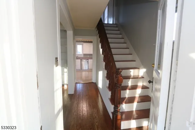 a view of a hallway with wooden floor and windows