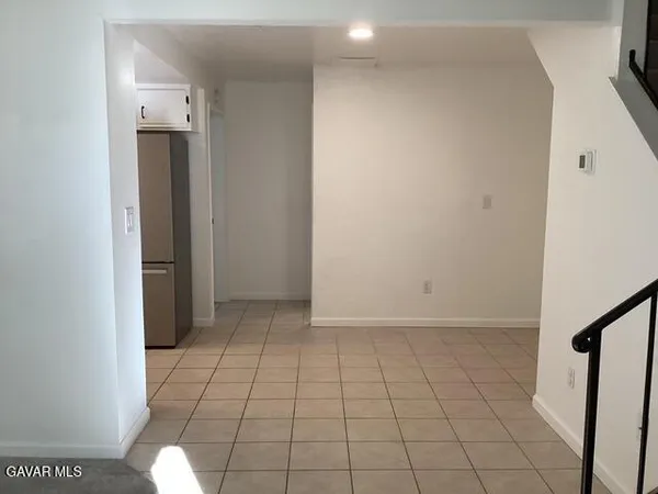 an empty room with an entryway and sink