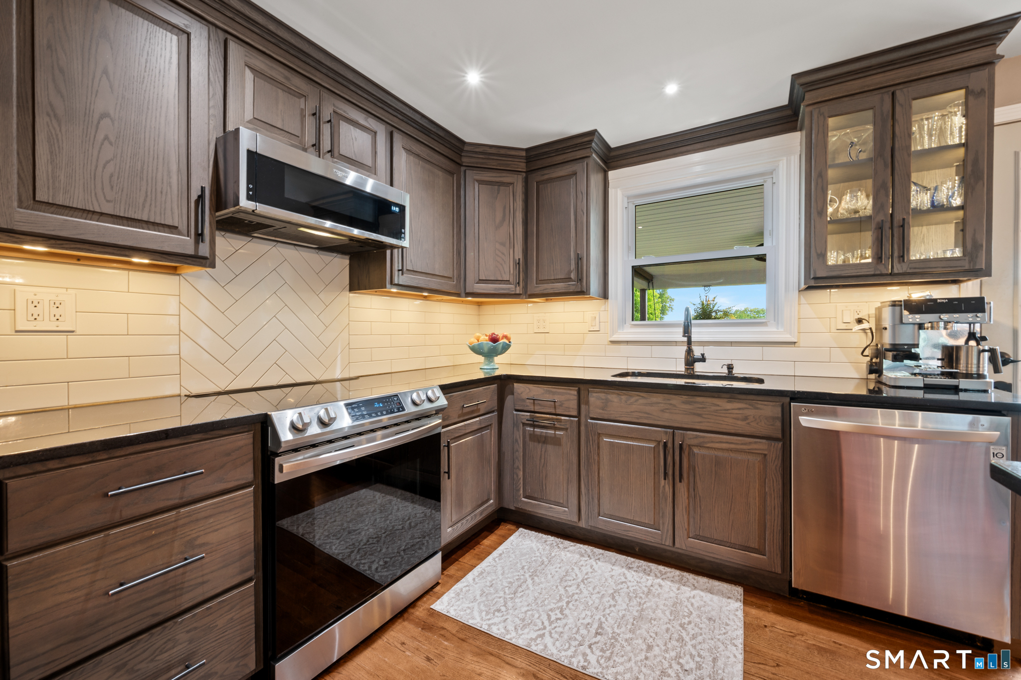 201 Ridge Crest Circle Wethersfield, CT 06109 - Photo 5 of 35 a kitchen with granite countertop wooden cabinets stainless steel appliances and a window