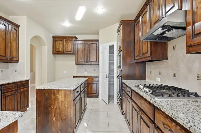 a kitchen with stainless steel appliances granite countertop a stove a sink dishwasher and a refrigerator