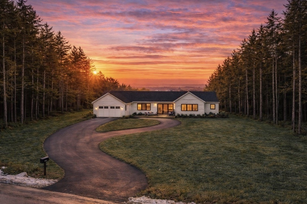 a view of a big house with a big yard and large trees