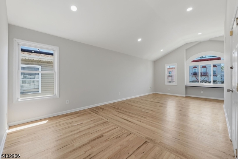 130 3rd Street, Unit 2 Passaic, NJ 07055 - Photo 5 of 12 a view of an empty room with a window and wooden floor