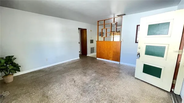 a view of an empty room with a fireplace and a window