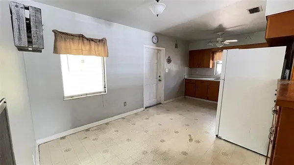 a kitchen with refrigerator and white cabinets