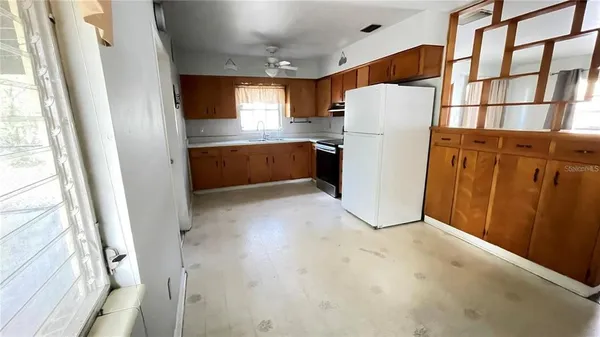 a white refrigerator freezer and a stove sitting inside of a kitchen