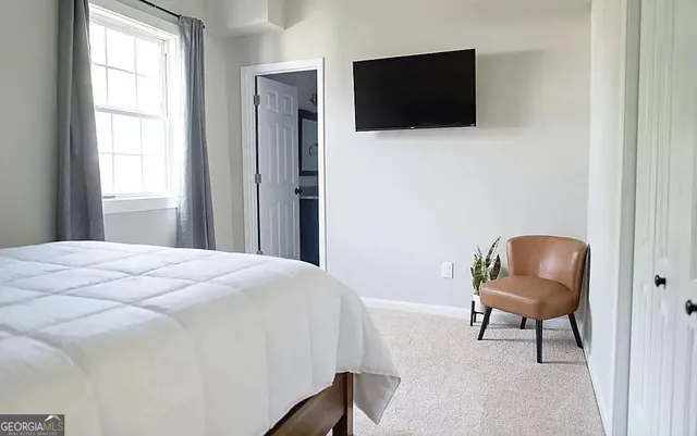 a bed sitting in a bedroom next to a window