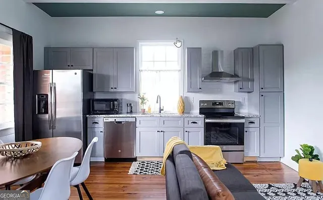 a kitchen with a refrigerator a stove a sink and a dining table with chairs