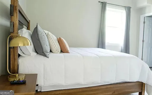 a bedroom with a chair and a flat screen tv