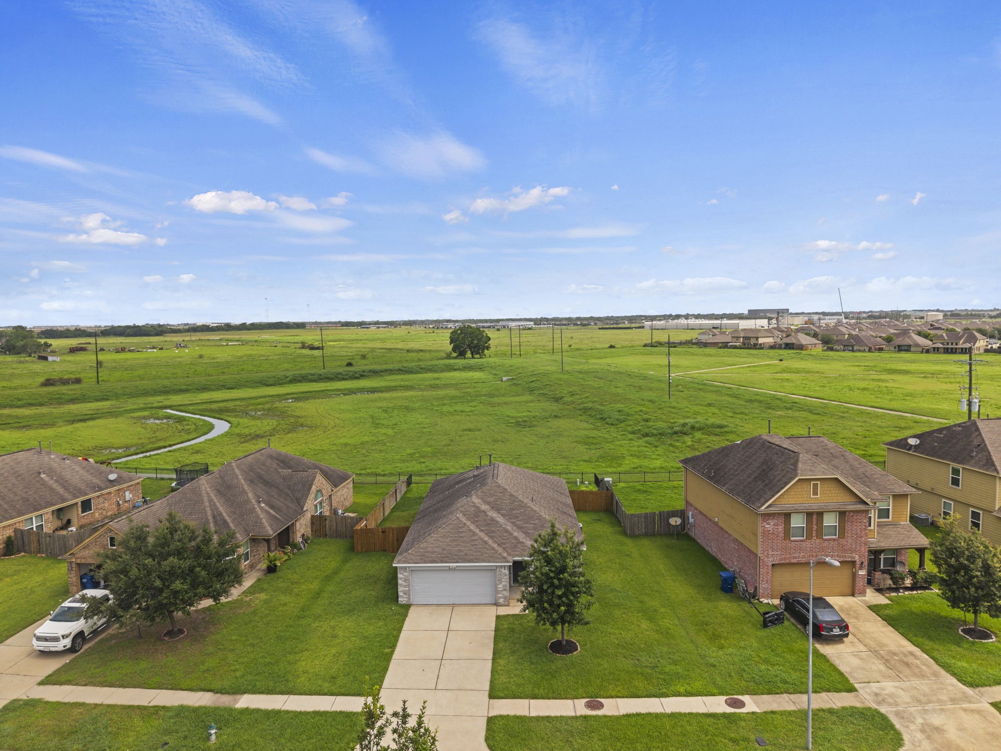 2110 Red Cedar Trail Rosenberg, TX 77471 - Photo 18 of 20 This spectacular aerial shot highlights the home's premier positioning, backing up to an expansive, lush green field that ensures long-term tranquility.