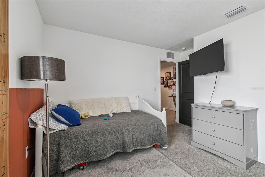 3139 Silver Date Drive Wimauma, FL 33598 - Photo 22 of 47 a bedroom with a bed and a flat screen tv