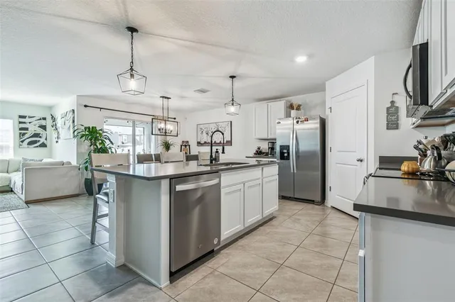 a kitchen with stainless steel appliances granite countertop a refrigerator sink and microwave