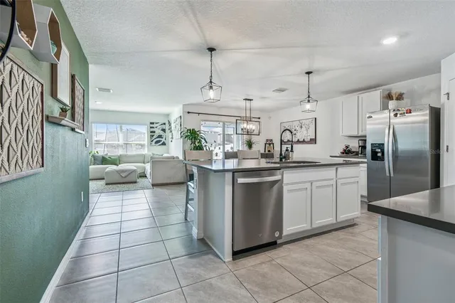 a kitchen with stainless steel appliances granite countertop white cabinets stove top oven and sink