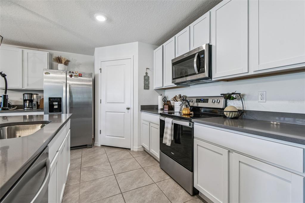 3139 Silver Date Drive Wimauma, FL 33598 - Photo 6 of 47 a kitchen with stainless steel appliances granite countertop a refrigerator sink and microwave