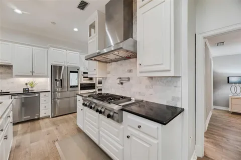 a kitchen with stainless steel appliances a stove a sink and a refrigerator