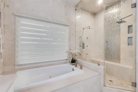a bathroom with a granite countertop sink mirror and a bathtub
