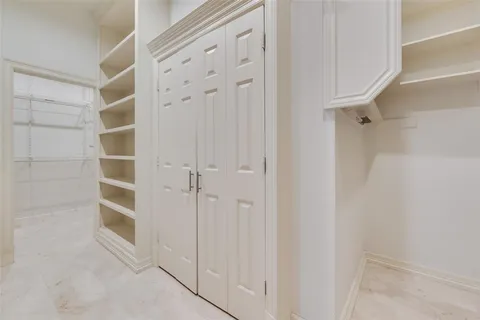 a spacious bathroom with a granite countertop double vanity and a mirror