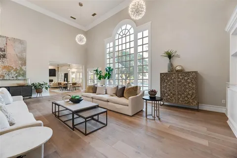 a living room with furniture a chandelier and a window