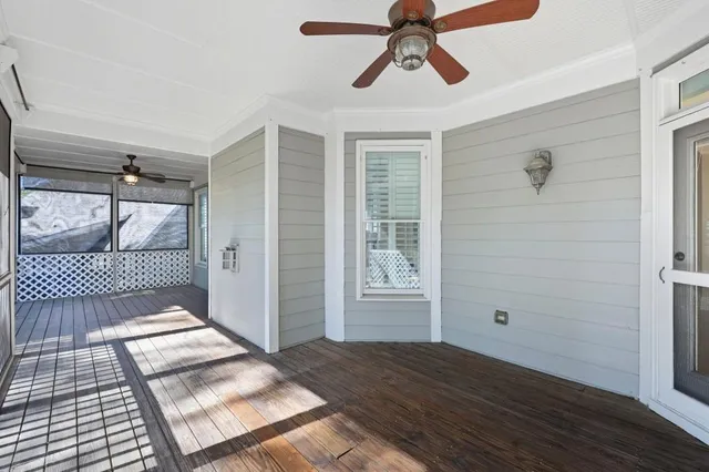 a view of a hallway with wooden floor and windows