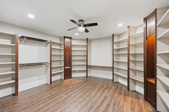 a view of a walk in closet with wooden floor and closet