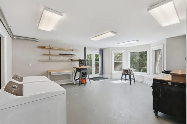 a view of a workspace with furniture and a window