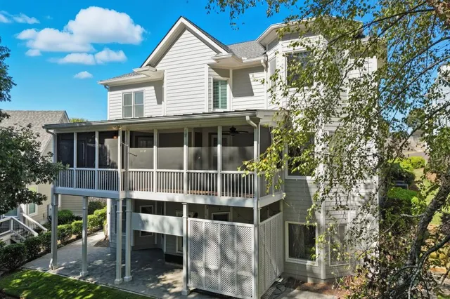 a view of a blue house with large windows and a tree