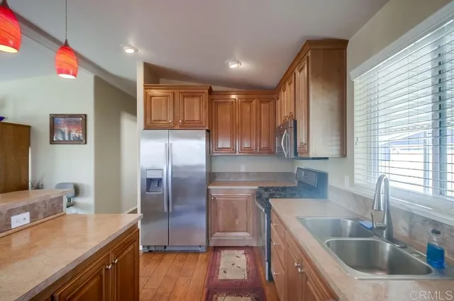 a kitchen with kitchen island granite countertop a sink refrigerator and microwave