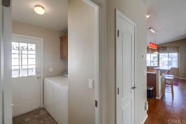 a view of hallway with window and wooden floor