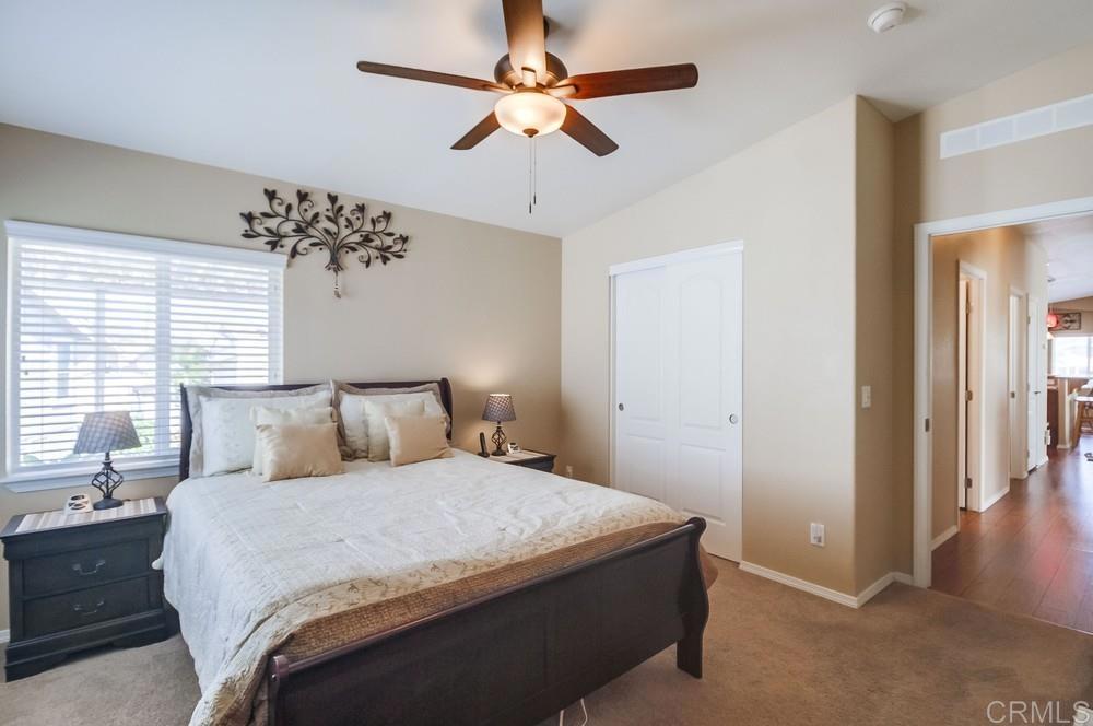 8545 Mission Gorge Road, Unit SPC 232 Santee, CA 92071 - Photo 24 of 30 a bedroom with a large bed and a chandelier