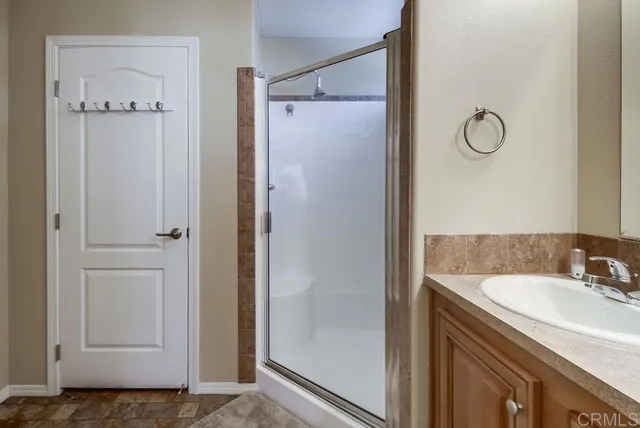 a bathroom with a shower sink and mirror