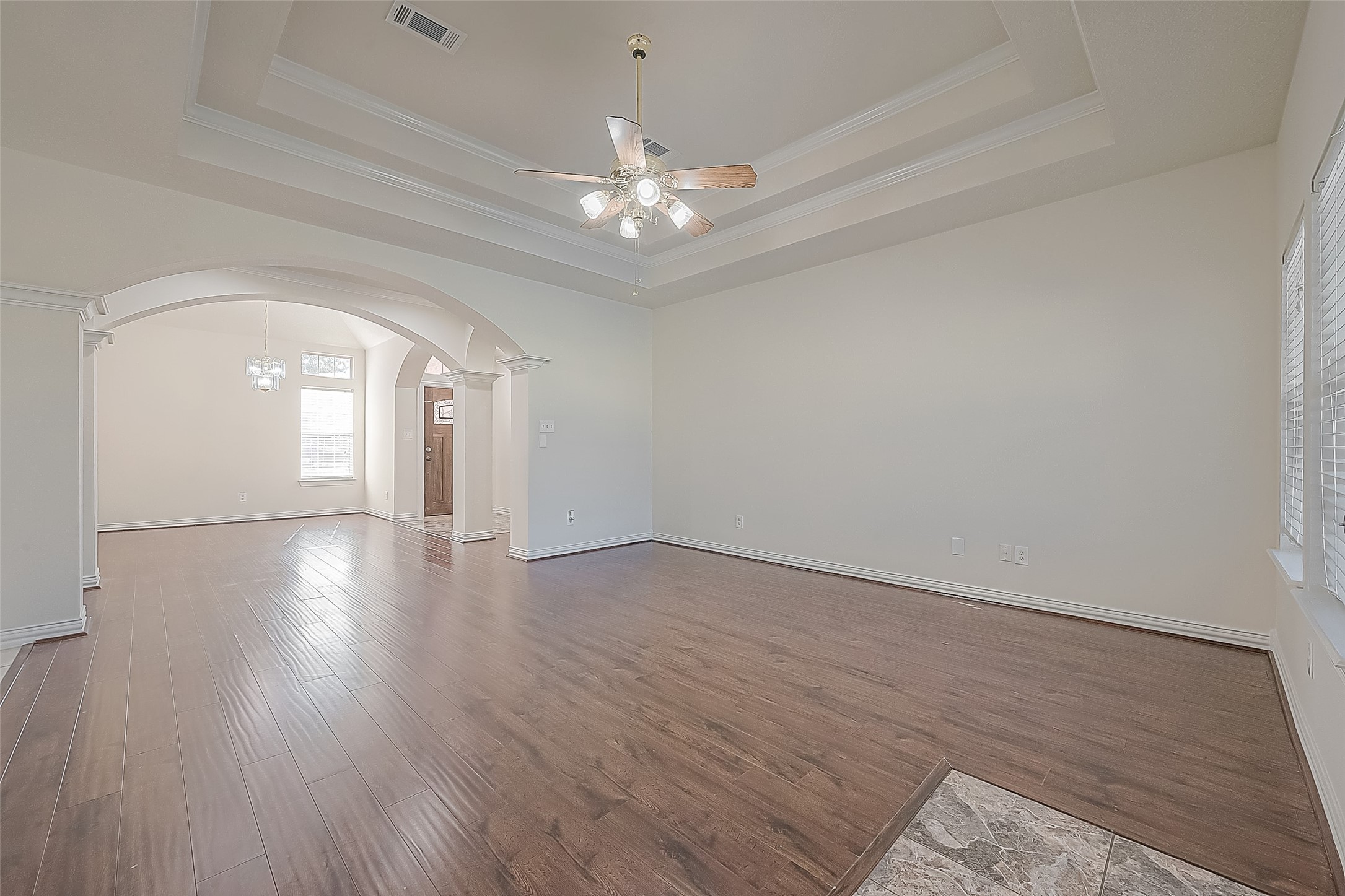 1189 Lovett Street Tomball, TX 77375 - Photo 13 of 36 a view of an empty room with wooden floor and a ceiling fan