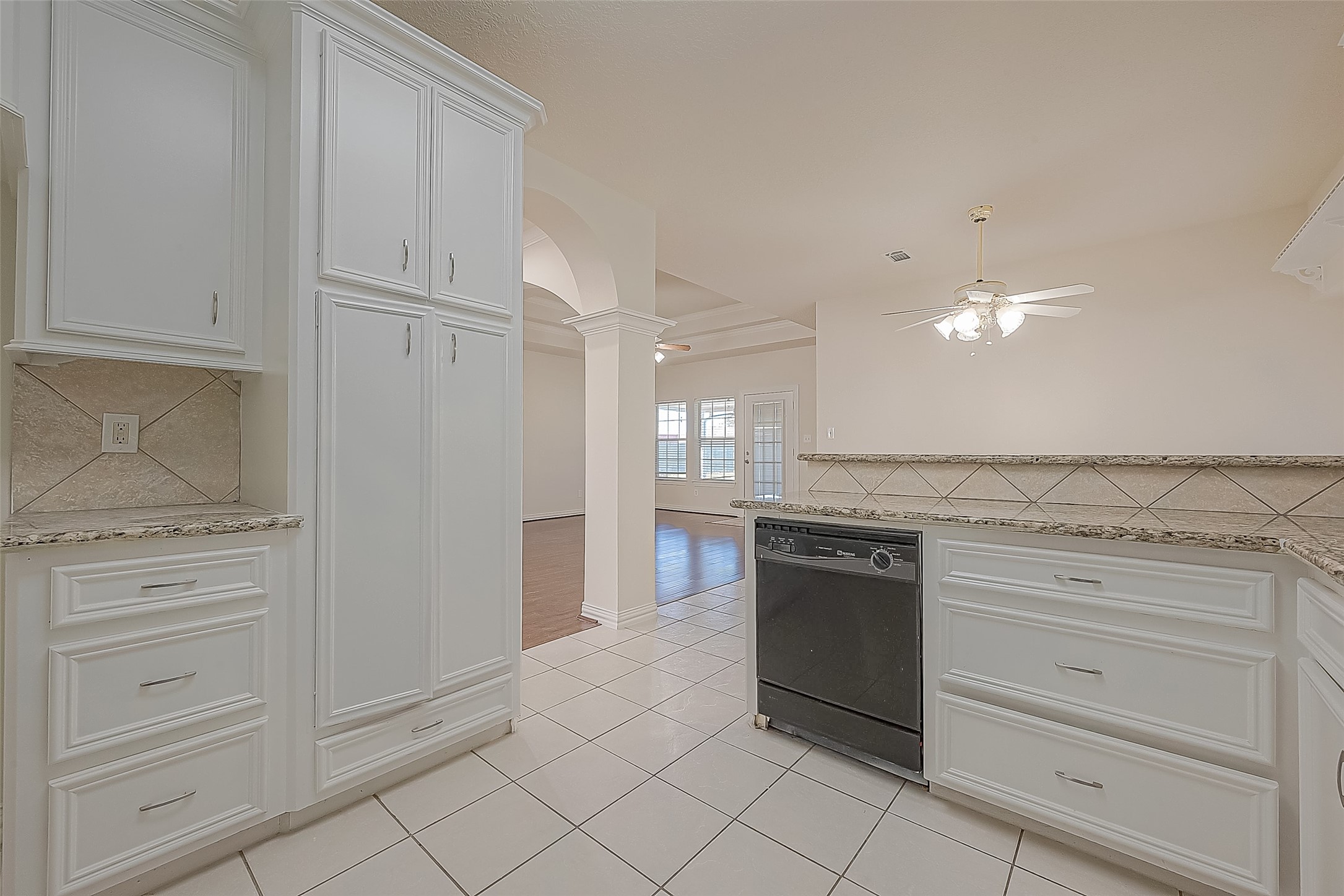 1189 Lovett Street Tomball, TX 77375 - Photo 21 of 36 a kitchen with granite countertop white cabinets and stainless steel appliances