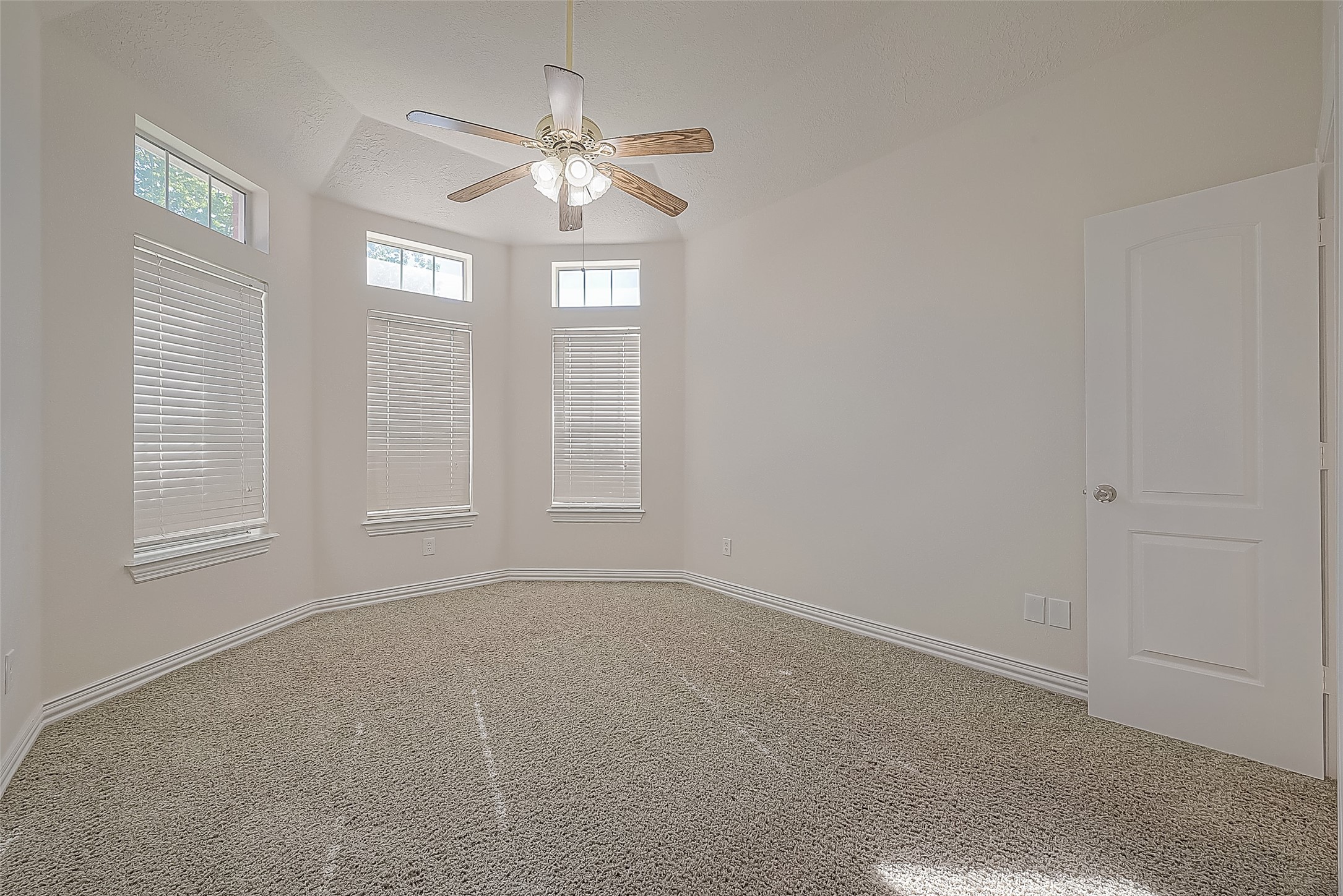 1189 Lovett Street Tomball, TX 77375 - Photo 10 of 36 an empty room with windows and chandelier fan