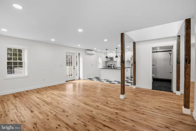 a view of empty room with wooden floor and window
